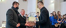 Starosta Kraśnicki Andrzej Rolla oraz Przewodniczący Rady Powiatu w Kraśniku wręczają podziękowania Panu Wojciechowi Durakowi Kapelmistrzowi Parafialnej Orkiestry Dętej z Szastarki.