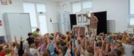 Dzieci oglądają sztukę teatralną z udziałem aktorów