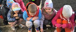 Dzieci pozują do zdjęcia przy kwiatach 
