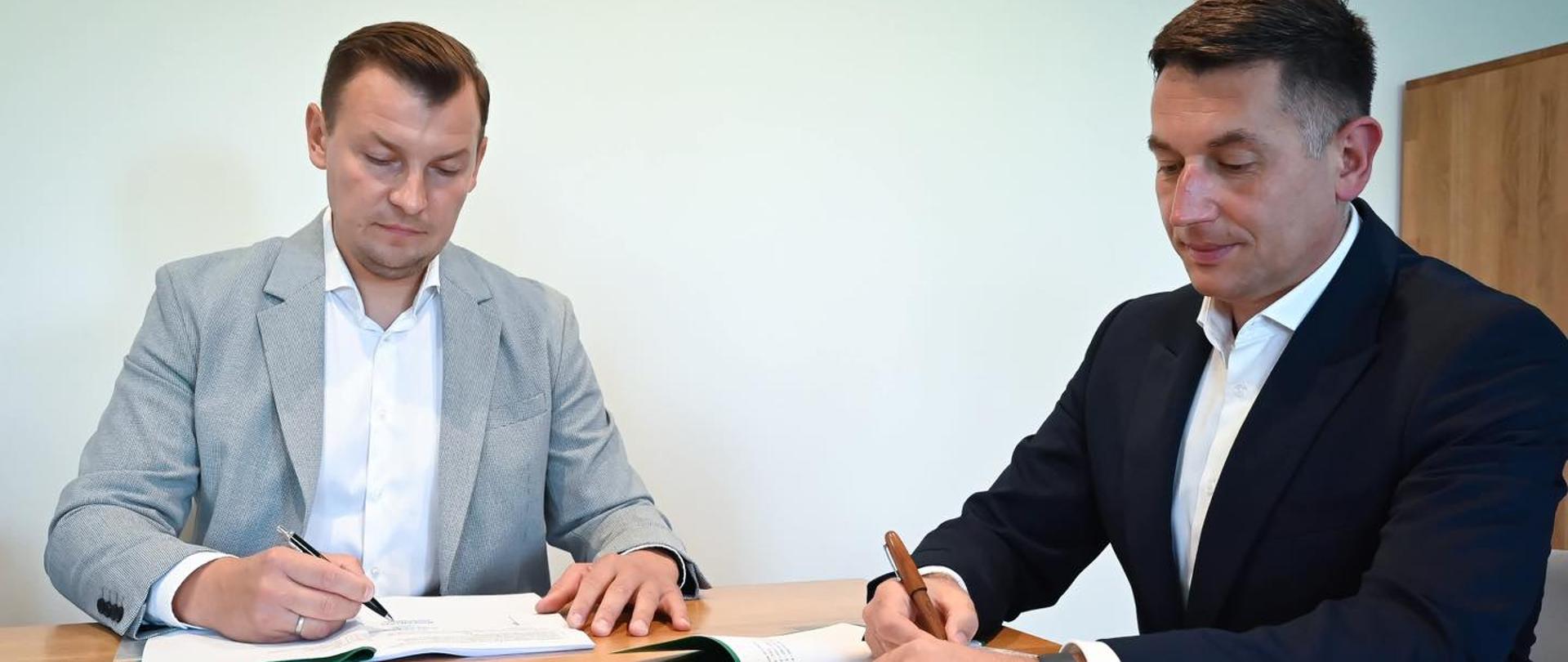 Pan Burmistrz i wykonawca podpisują umowę.