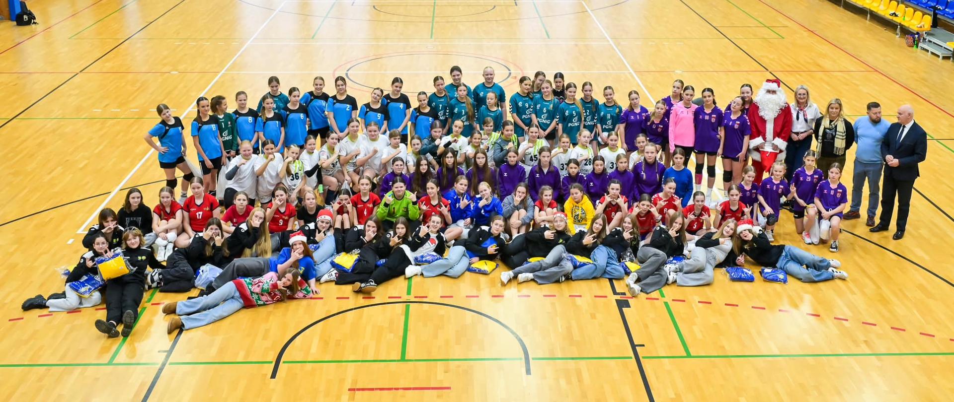 Uczestniczki turnieju oraz trenerzy, organizatorzy i zaproszeni goście na hali sportowej