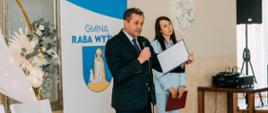 Życzenia składane jubilatom przez wójta Gminy Raba Wyżna w tle widać Kierownik USC oraz roll up z napisem Gmina Raba Wyżna.