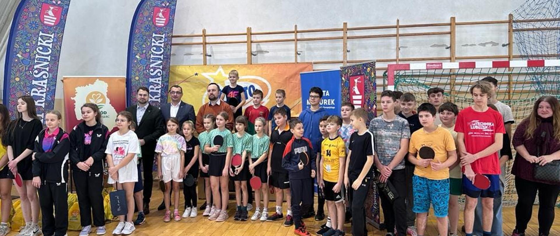 Otwarcie mistrzostw. Wśród młodych zawodników stoi Starosta Kraśnicki, Prezes Stowarzyszenia Wschód Lubelskich Serc oraz Wójt Gminy Trzydnik Duży.