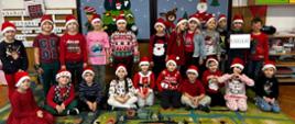 Dzieci z czapkach św. Mikołaja pozują do wspólnego zdjęcia