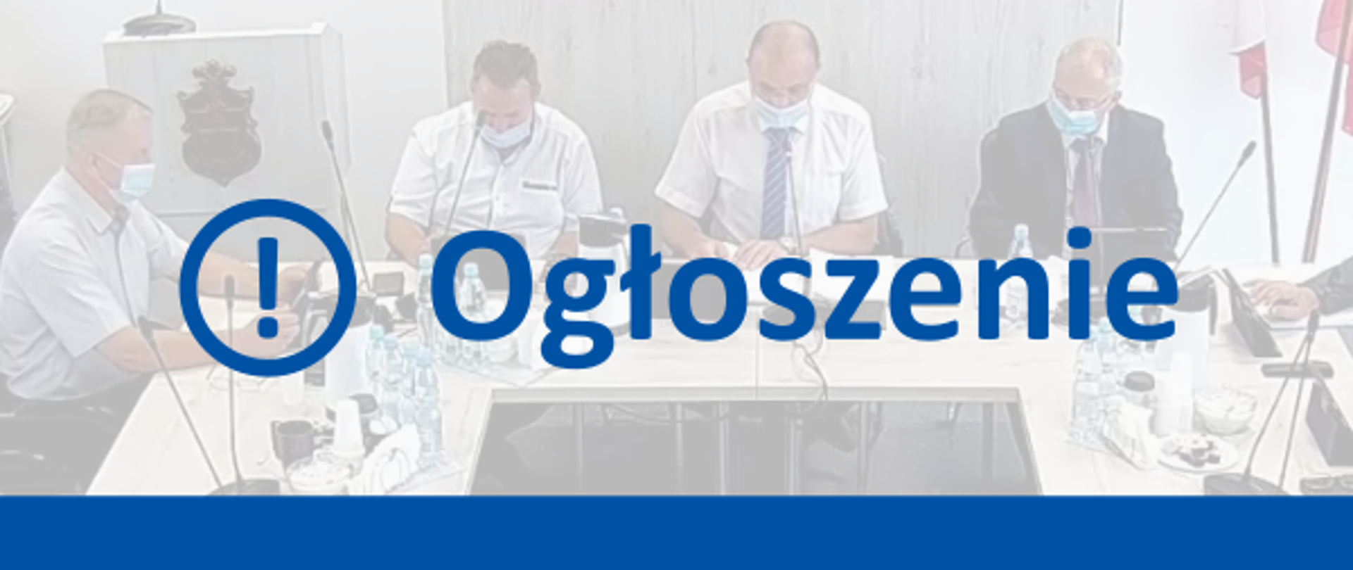 Niebieski napis "ogłoszenie" i niebieska linia pozioma przy dolnej krawędzi grafiki. W tle fotografia radnych siedzący w maseczkach przy stołach.