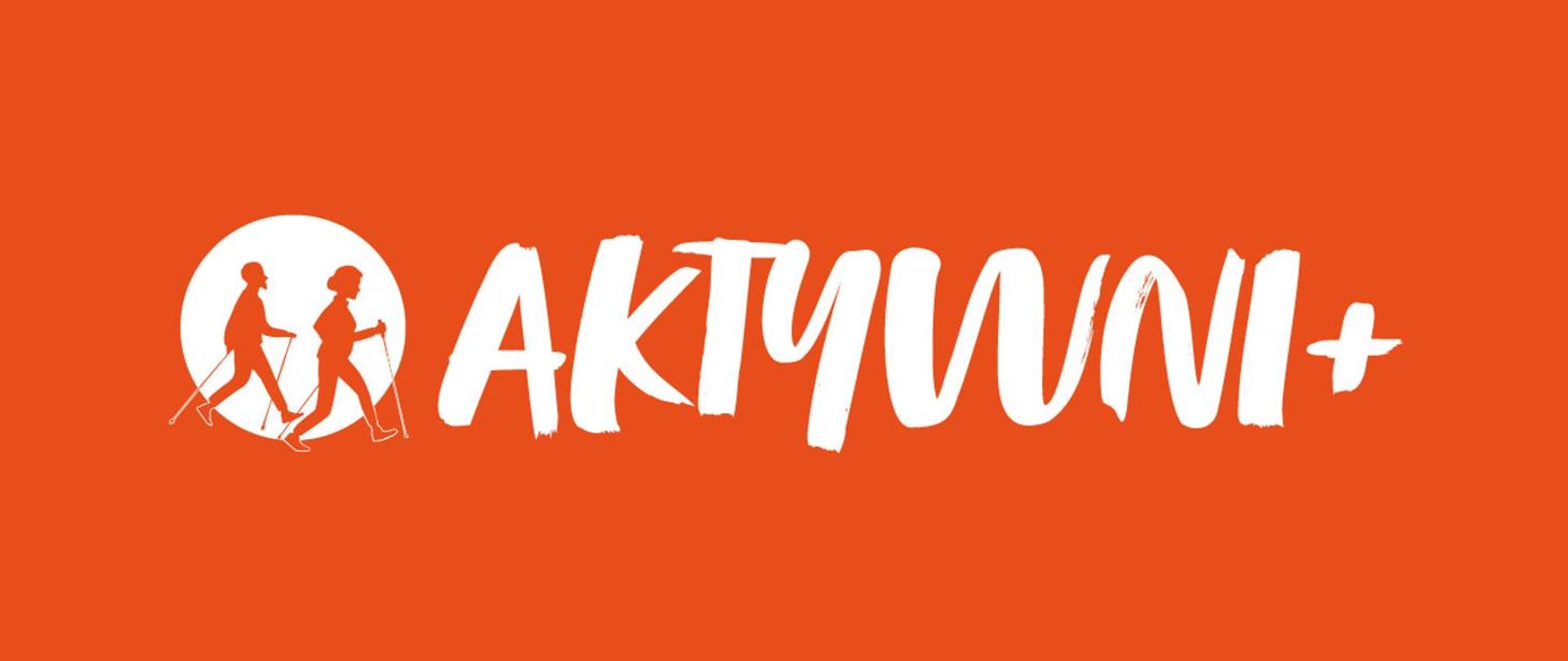 Logo programu Aktywni plus na czerwonym tle biały napis. Przed literą a biały okręg, na jego tle widać dwie sylwetki mężczyzny i kobiety maszerujących z kijkami.