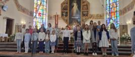 kolaż trzech zdjęć z kościoła w Rokicinach Podhalańskich dzieci przy ołtarzu ubrane w barwy biało granatowe śpiewają pieśni religijne. W tle ołtarz i witraże.