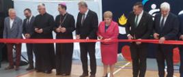 Otwarcie sali gimnastycznej w szkole podstawowej w Topczewie - starosta bielski Sławomir Jerzy Snarski przecina wstęgę obok biskupa drohiczyńskiego Piotra Sawczuka i podlaskiej kurator oświaty Beaty Pietruszki 