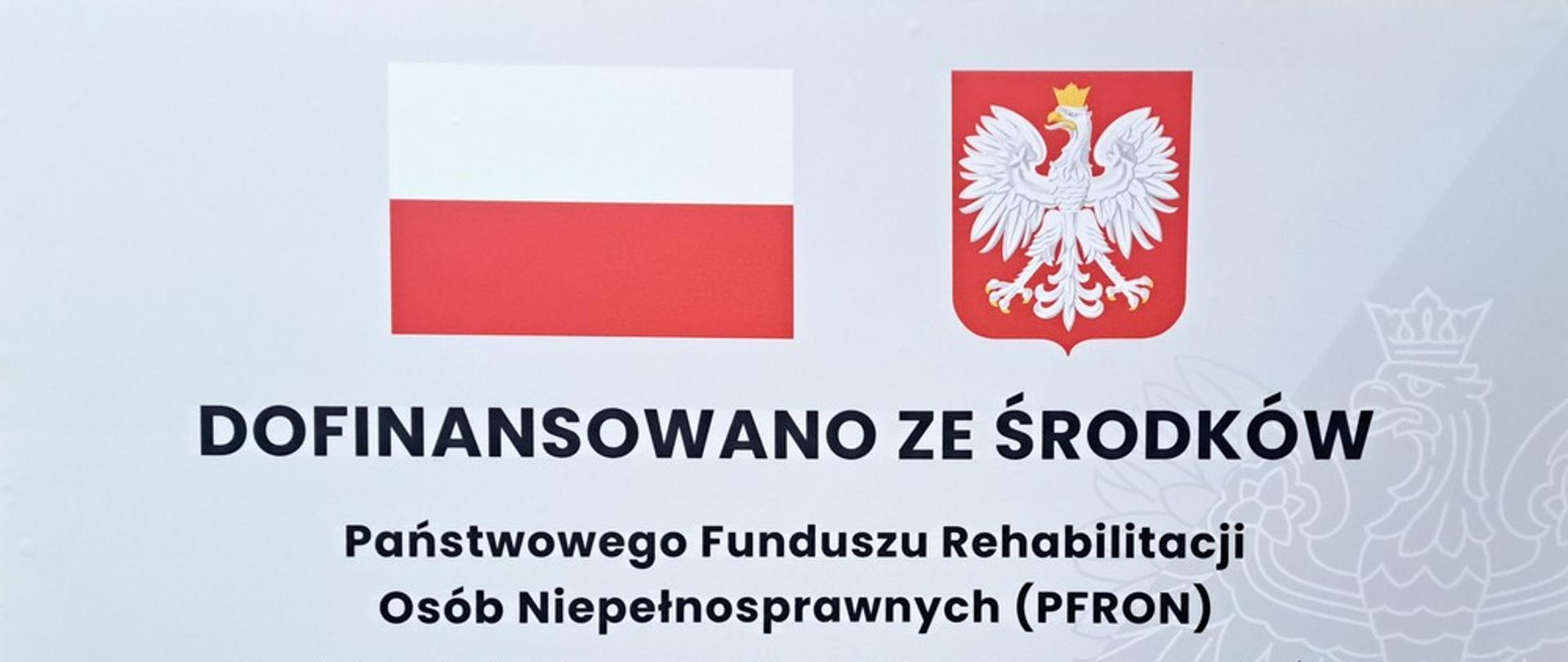 Tablica informacyjna z biało-czerwonymi barwami i godłem Polski informująca o dofinansowaniu projektu ze środków Państwowego Funduszu Rehabilitacji Osób Niepełnosprawnych (PFRON). Tekst dotyczy zmniejszenia barier transportowych dla uczestników Środowiskowego Domu Samopomocy w Kalwarii Zebrzydowskiej poprzez zakup 9-osobowego mikrobusa dostosowanego do przewozu osób z niepełnosprawnościami. Na tablicy podano kwotę dofinansowania 151 000 zł, całkowitą wartość zadania 207 870 zł oraz datę podpisania umowy 24.09.2025 r.