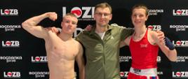 Na ściance Lubelskiego Okręgowego Związku Bokserskiego stoją od lewej: Patryk Zarębski, trener Michał Lenartowicz i Jan Wójcik