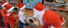 Mikołajki w przedszkolu - Mikołaj rozdaje dzieciom prezenty
