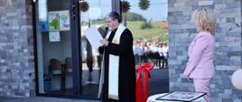 Poświęcenie budynku przez księdza. 
