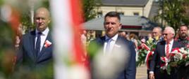 Burmistrz i zastępca burmistrza składają kwiaty. 