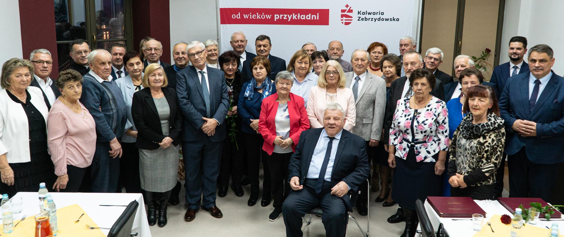 Zdjęcie przedstawia jubilatów, burmistrza, przewodniczącego rady, którzy licznie zgromadzili się na obchodach 50-lecia pożycia małżeńskiego.