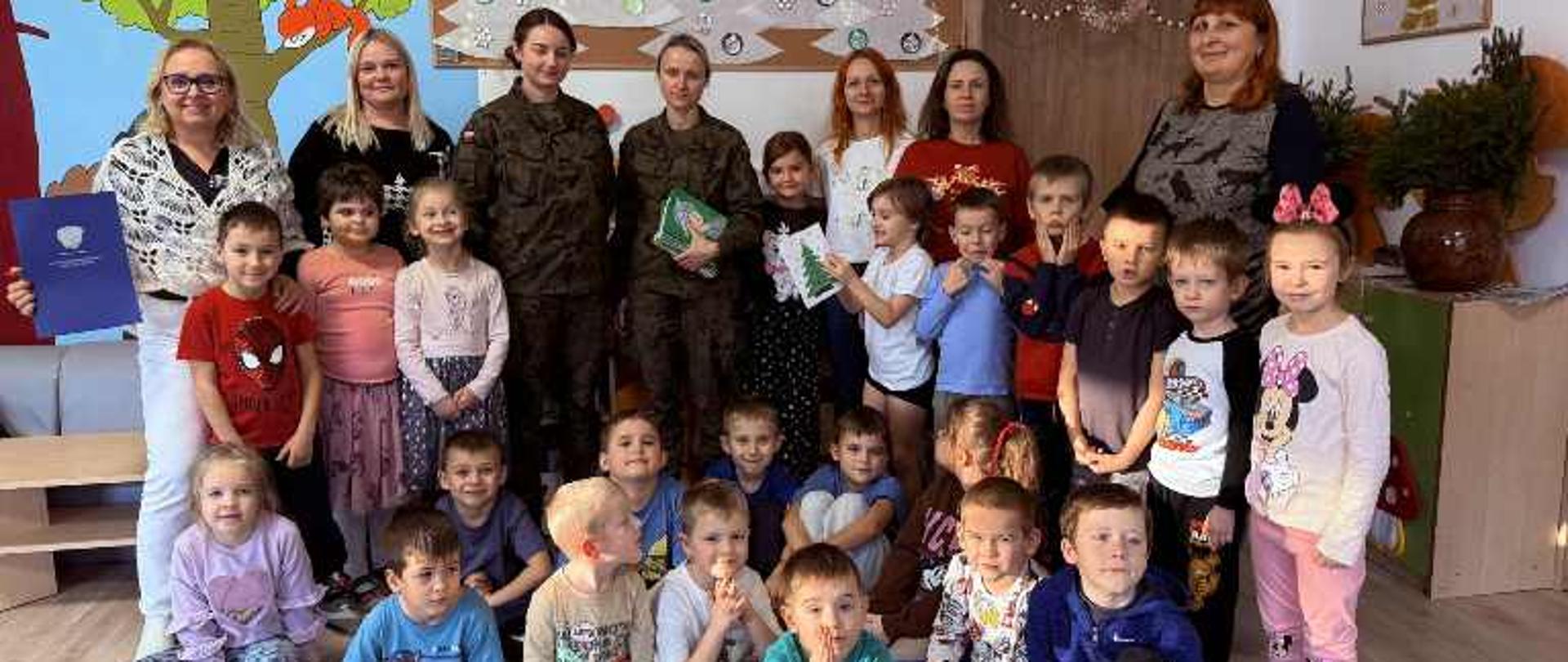 Przedstawiciele Wojska Polskiego pozują do zdjęcia z grupą przedszkolną