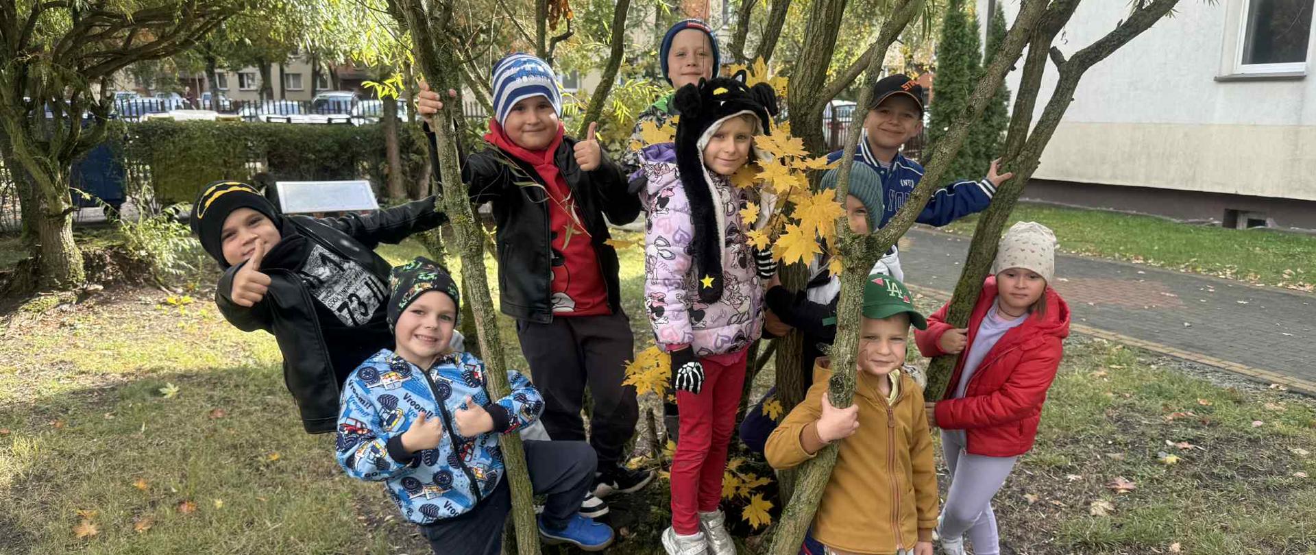 Dzieci przytulają drzewa