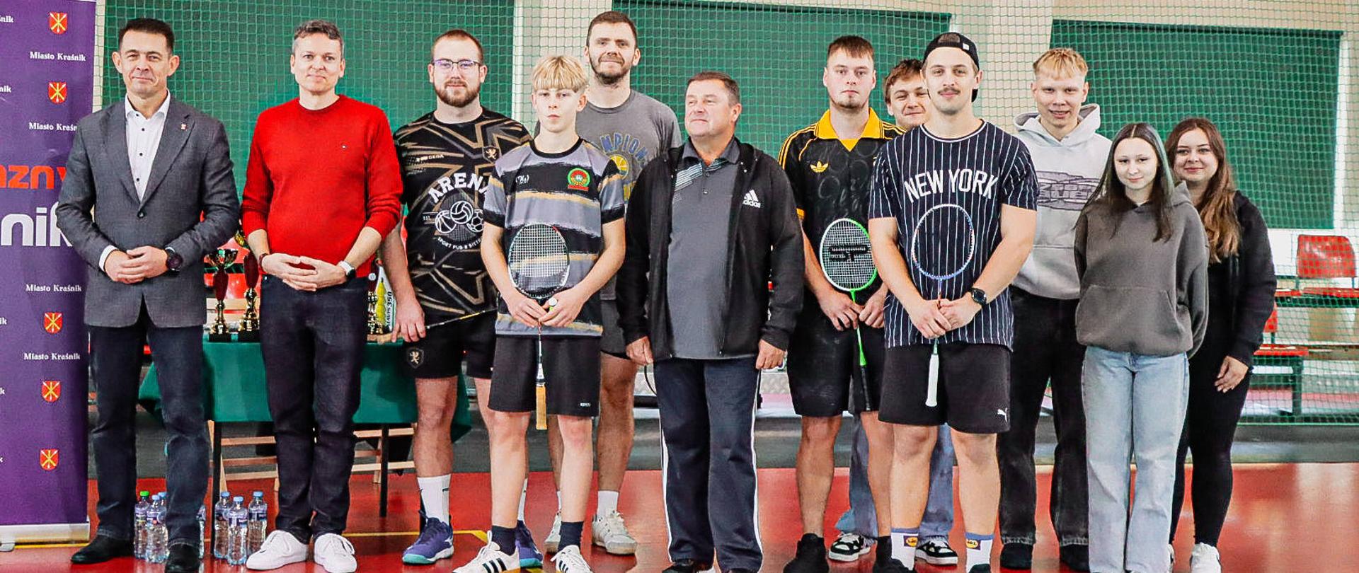 Zawodnicy turnieju stojący na hali sportowej Zespołu Szkół nr 3 w Kraśniku. Od strony lewej stoją: Przewodniczący Rady Powiatu w Kraśniku Jacek Dubiel i Radny Rady Miasta Kraśnik Mariusz Kwietniewski.