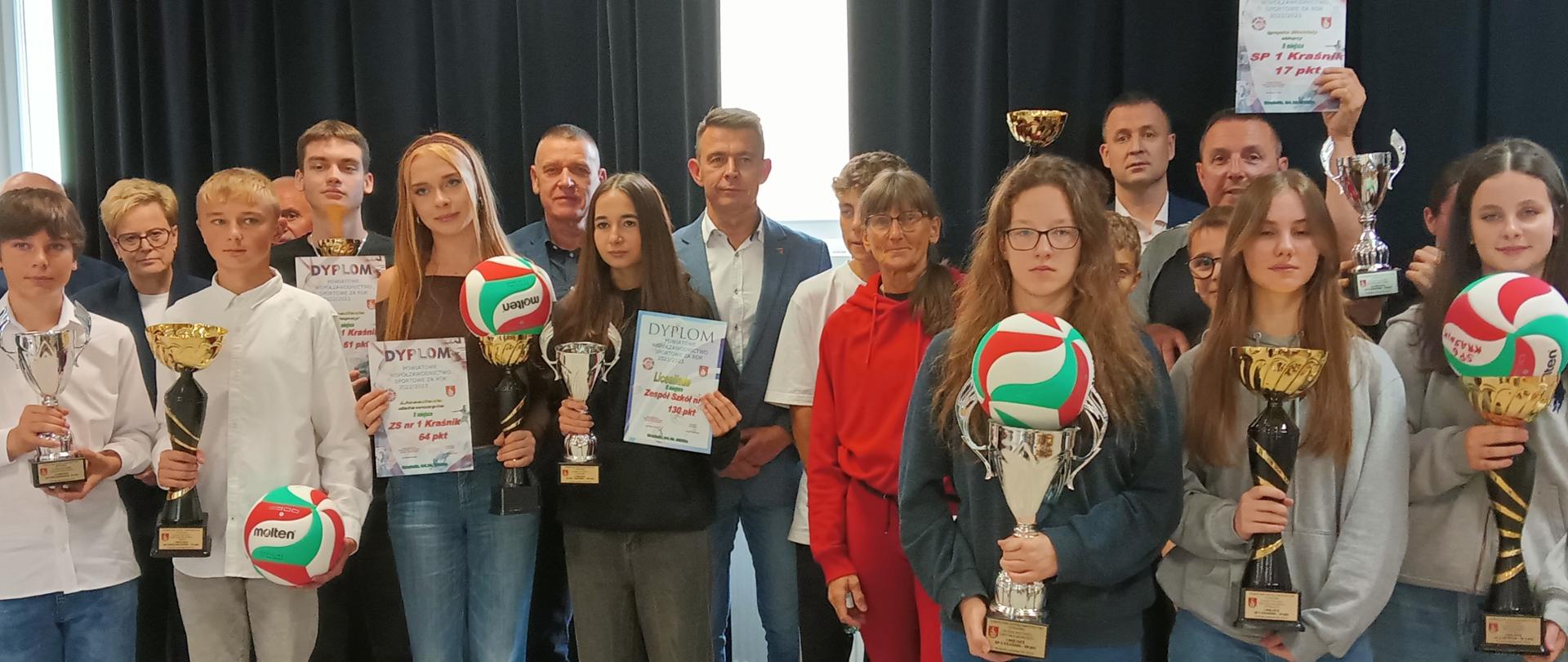 Nagrodzeni uczniowie wraz z nauczycielami i dyrektorami ze swoich szkół. Pośrodku stoi Przewodniczący Rady Powiatu w Kraśniku Jacek Dubiel