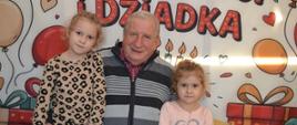 Dzieci pozują do zdjęcia z dziadkami