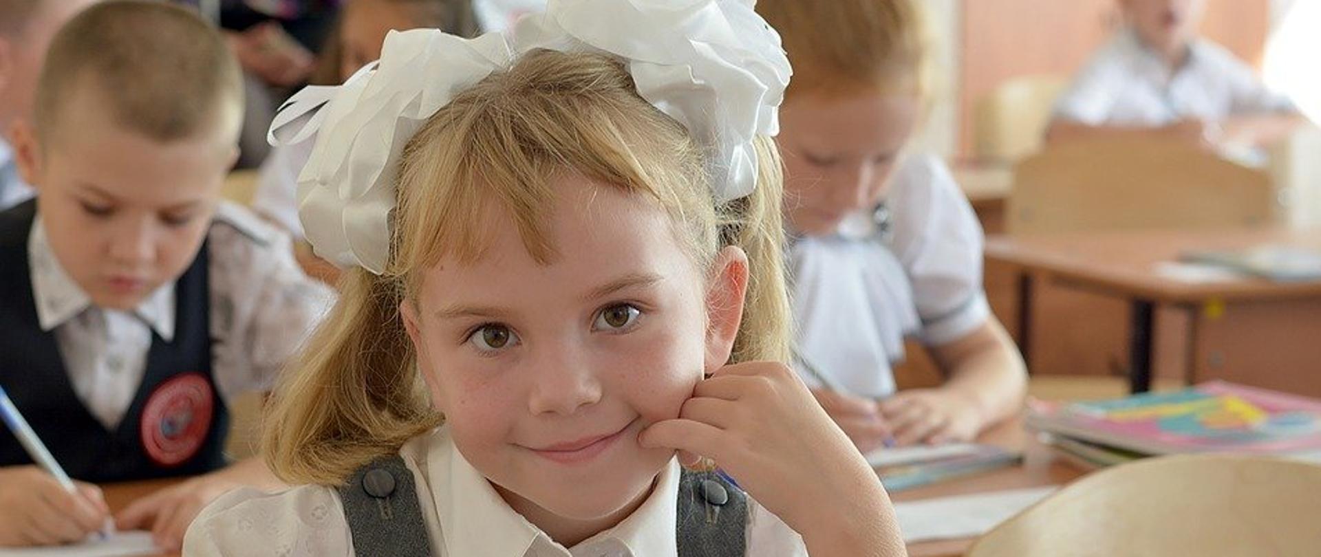 grafika przedstawia dziecko w szkole