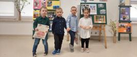 Czworo dzieci pozuje do zdjęcia na tle prezentacji podsumowującej konkurs