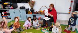 Zajęcia w grupie - dzieci siedzą przed nauczycielką, która omawia temat dnia