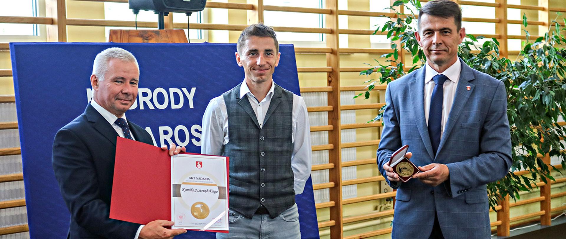 Wręczanie Medalu Starosty Kraśnickiego zawodnikowi Szkolnego Klubu Biegowego w Kraśniku Kamilowi Jastrzębskiemu przez Starostę Kraśnickiego Andrzeja Rollę oraz Przewodniczącego Rady Powiatu w Kraśniku Jacka Dubiela