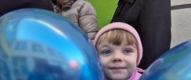 Dziewczynka pozuje z niebieskimi balonami
