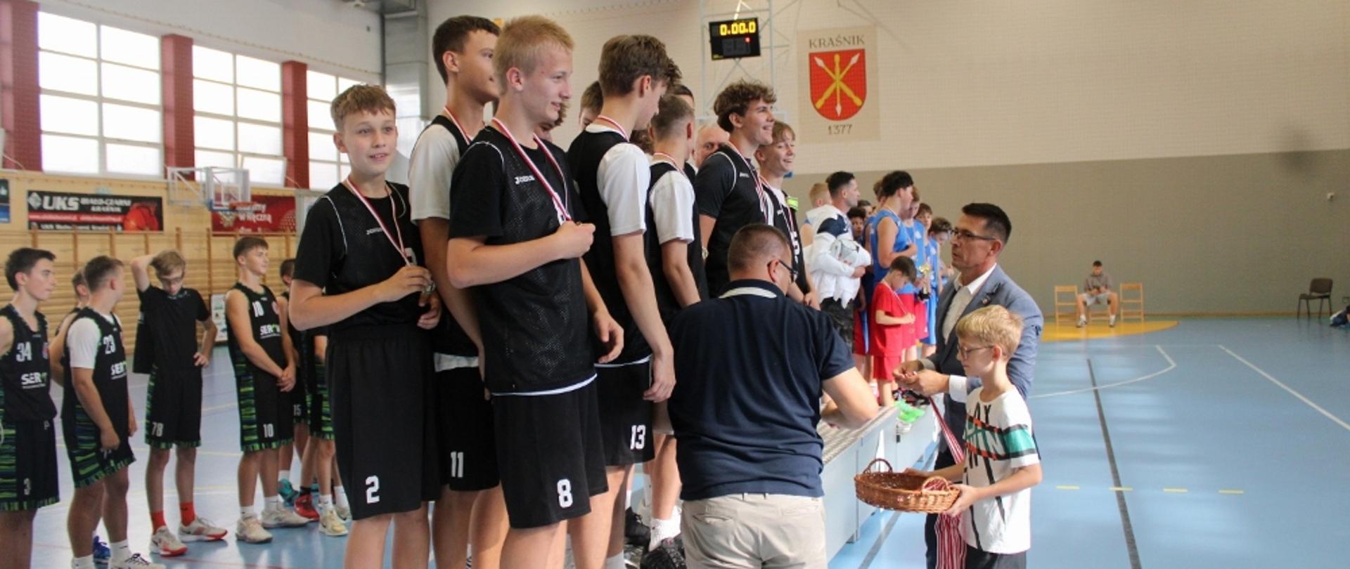 Wręczanie medali zawodnikom, stojącym na 2 stopniu podium w turnieju koszykówki chłopców przez prezesa Uczniowskiego Klubu Biało - Czarni Kraśnik Pawła Biskupa i Przewodniczącego Rady Powiatu w Kraśniku Jacka Dubiela.