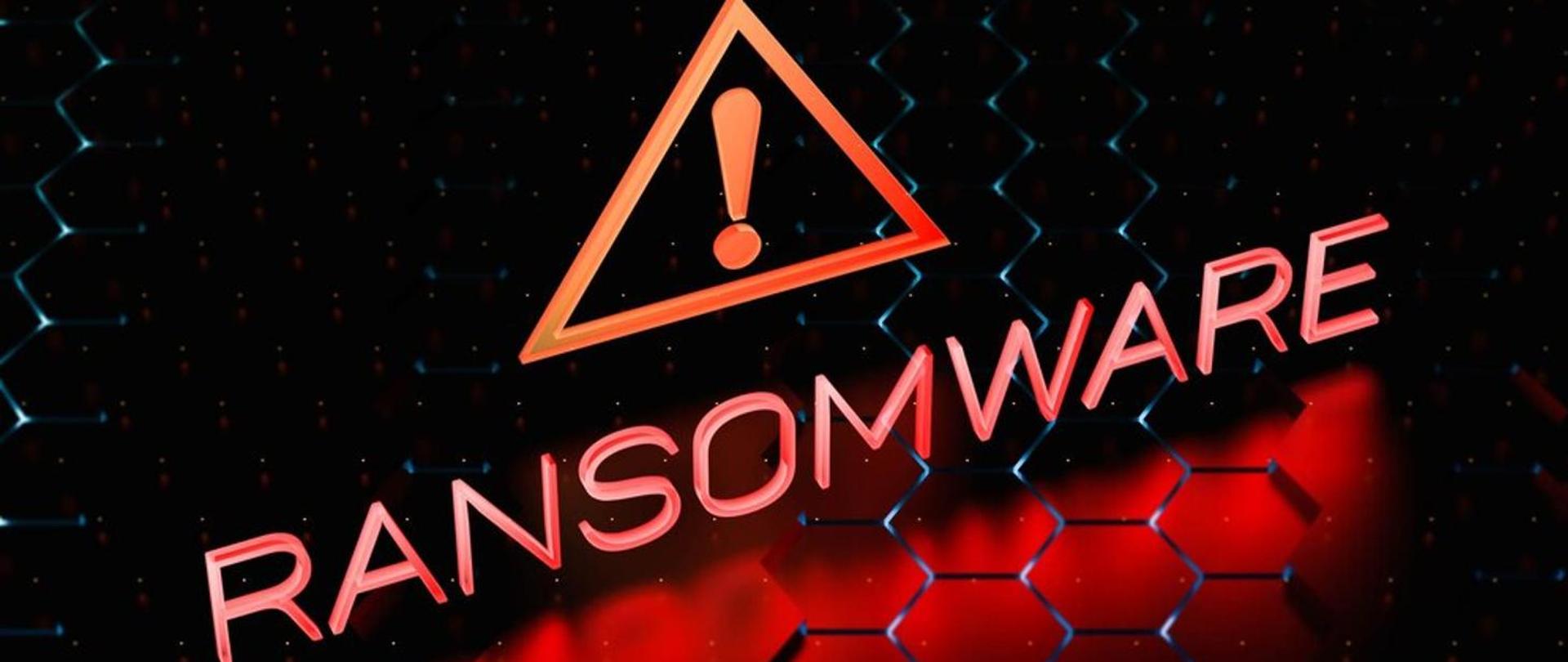 Na ciemnym tle bladoczerwony napis Ransomware, nad nim symbol wykrzyknika wpisanego w trójkąt.