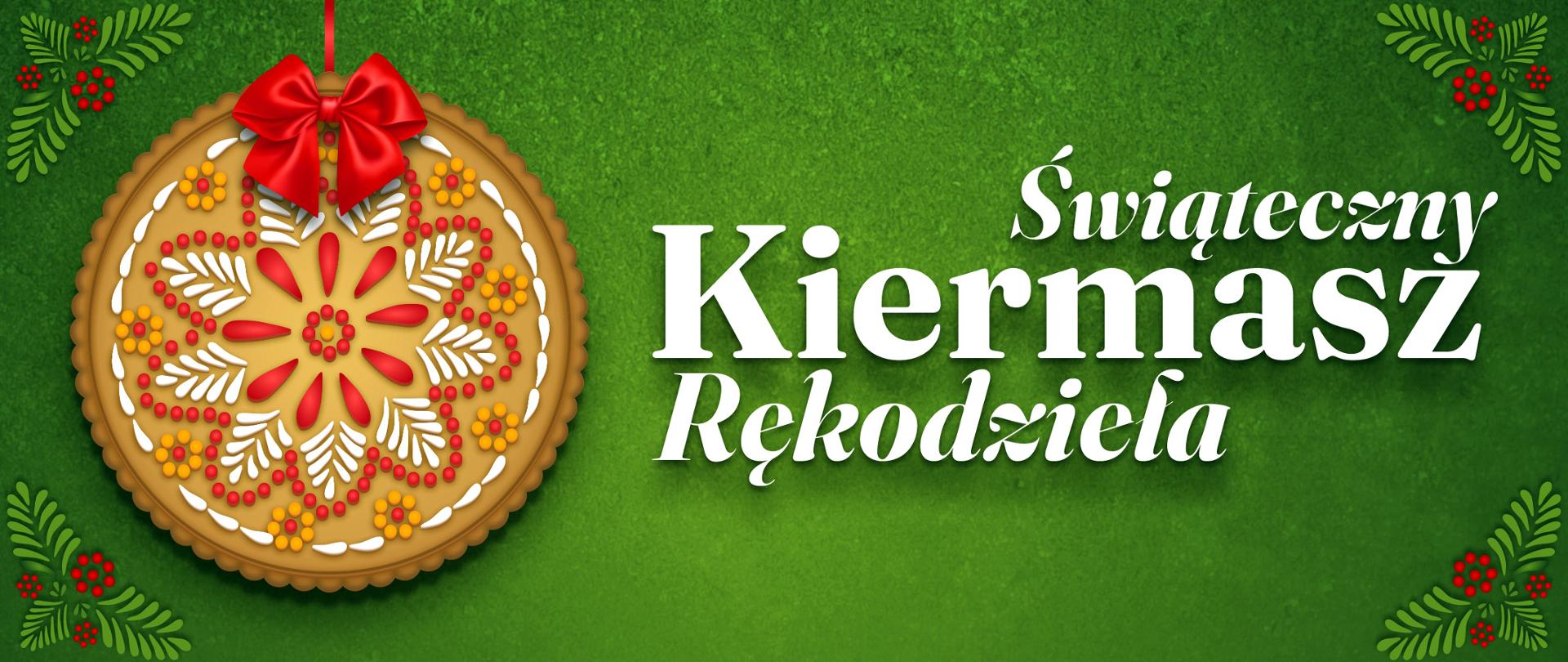 Baner reklamowy na zielonym, teksturowanym tle. Po lewej stronie widoczne jest duże, okrągłe, lukrowane piernikowe ciasteczko świąteczne, które przypomina bombkę choinkową, przewiązane czerwoną kokardą i zawieszone na czerwonej wstążce. Piernik ozdobiony jest białym, czerwonym i żółtym lukrem w geometryczny, ludowy wzór. W rogach znajdują się stylizowane, ludowe dekoracje z czerwonych jagód i zielonych gałązek. Centralnie, białymi literami, widnieje napis: "Świąteczny Kiermasz Rękodzieła".