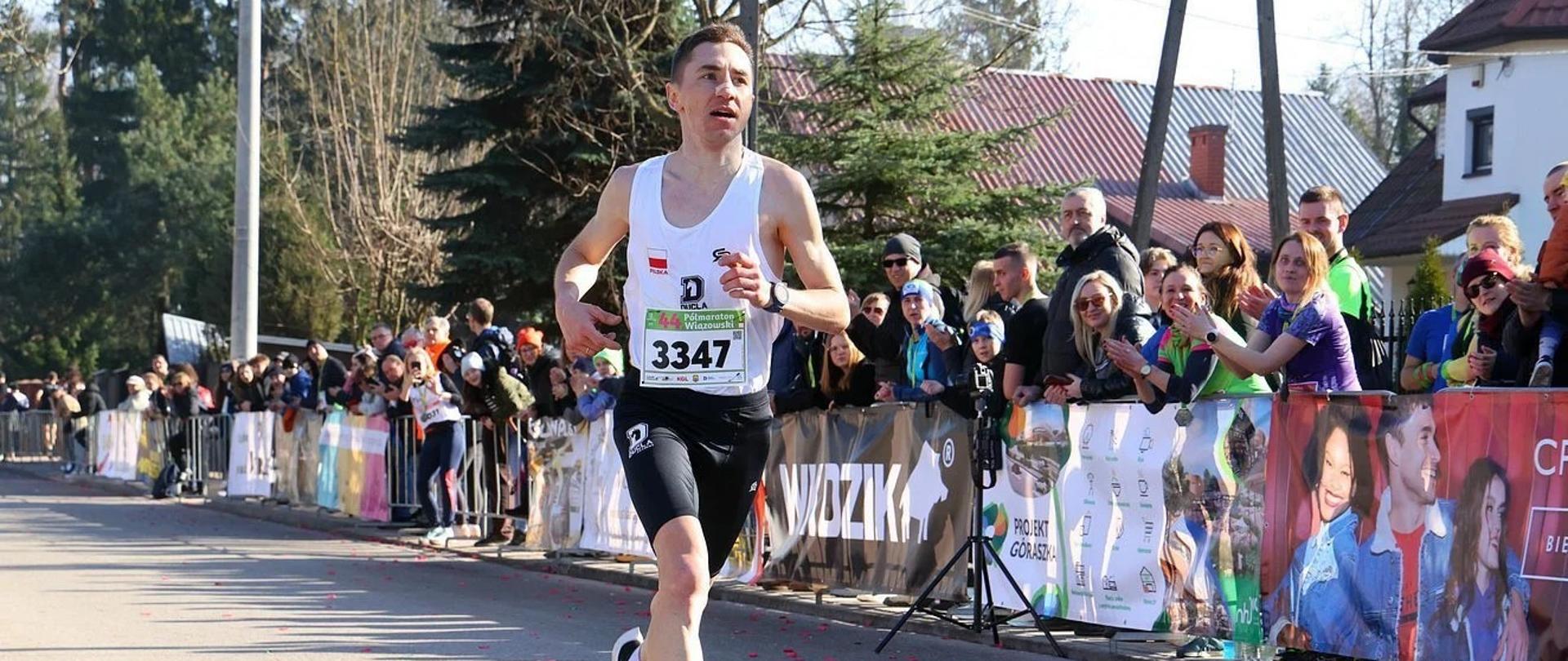 Kamil Jastrzębski na trasie biegu. Po prawej stronie widać licznie zgromadzoną publiczność