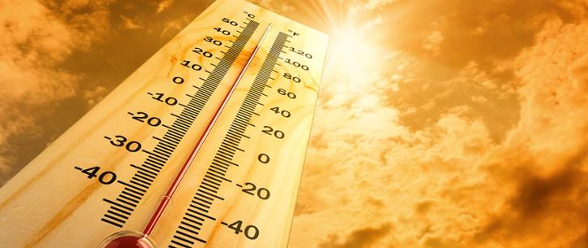 Zjecie termometru z wysoką temperatura, na tle nieba. 