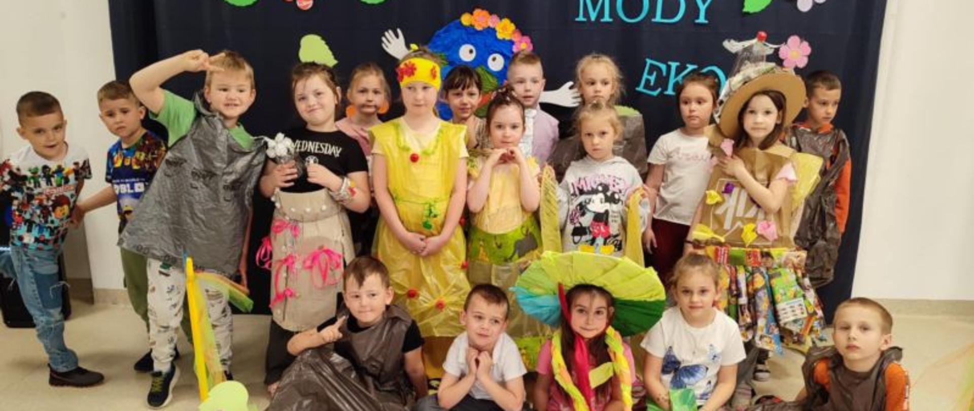 Dzieci ubrane w stroje z recyklingu pozują do zdjęcia