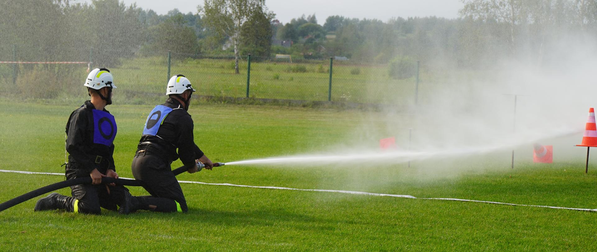 Na fotografii strażacy wykonujący zadanie podczas zawodów sportowo - pożarniczych. 