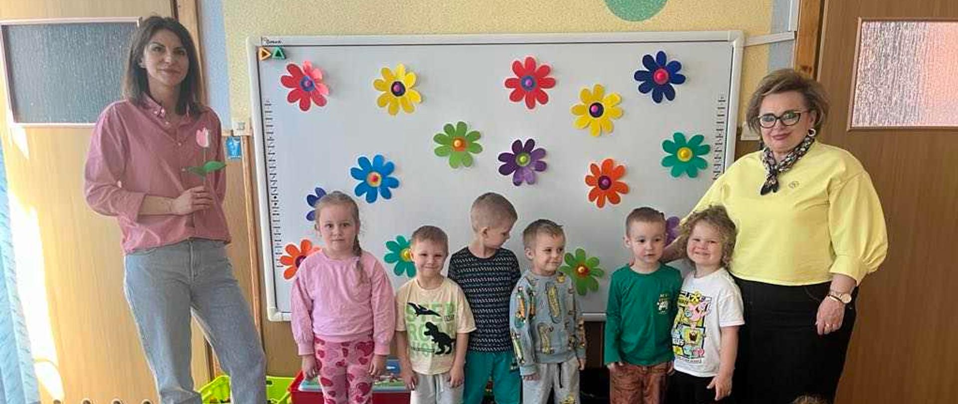 Dzieci, Pani nauczycielka oraz bibliotekarka pozują do wspólnego zdjęcia