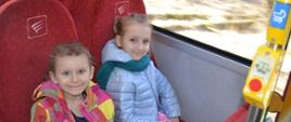 Dzieci siedzą w autokarze, pozują do zdjęcia