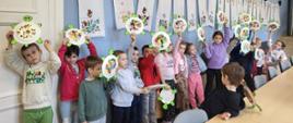 Dzieci prezentują efekty warsztatów artystycznych - kolorowe, papierowe żółwie
