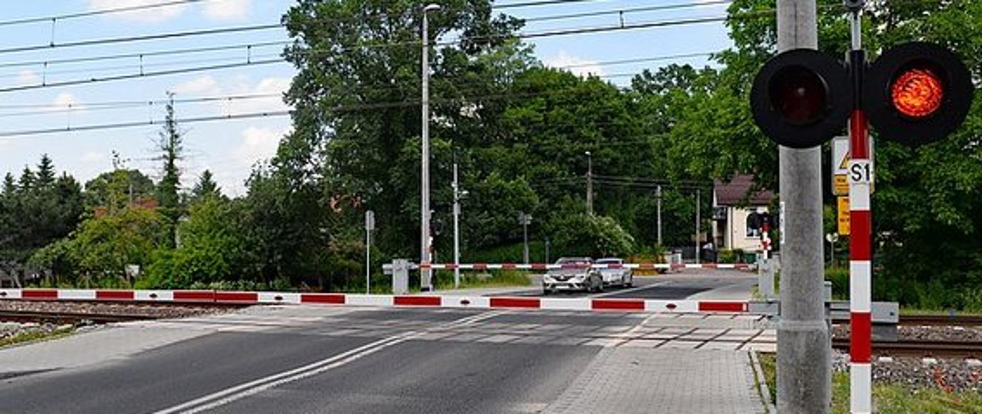 Przejazd przez tory za zamkniętymi rogatkami i włączoną sygnalizacją świetlną czerwoną