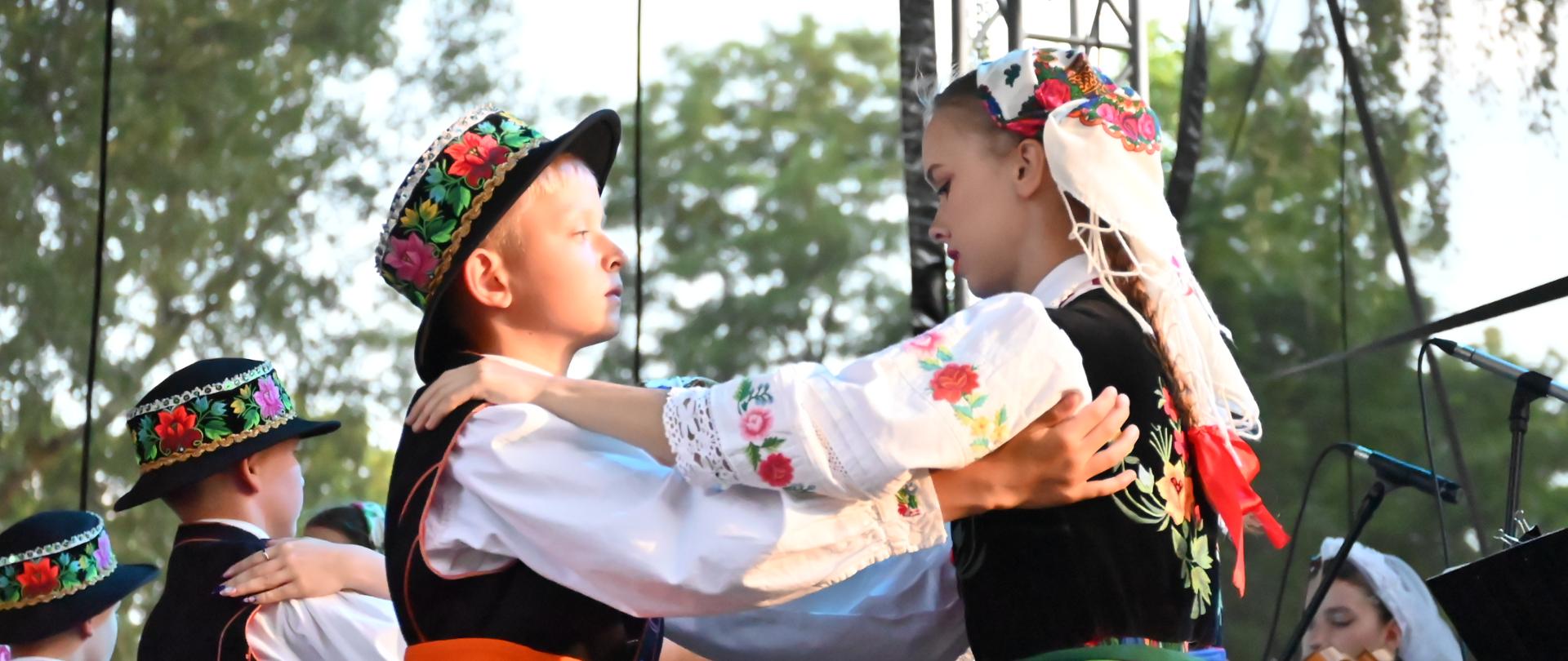 Para dzieci w łowickich strojach na scenie.