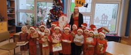 Mikołajki w przedszkolu - dzieci, nauczycielka i mężczyzna przebrany za św. Mikołaja pozują do zdjęć