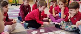 W trakcie zajęć - dzieci siedzą w kółku, przed nimi kartki