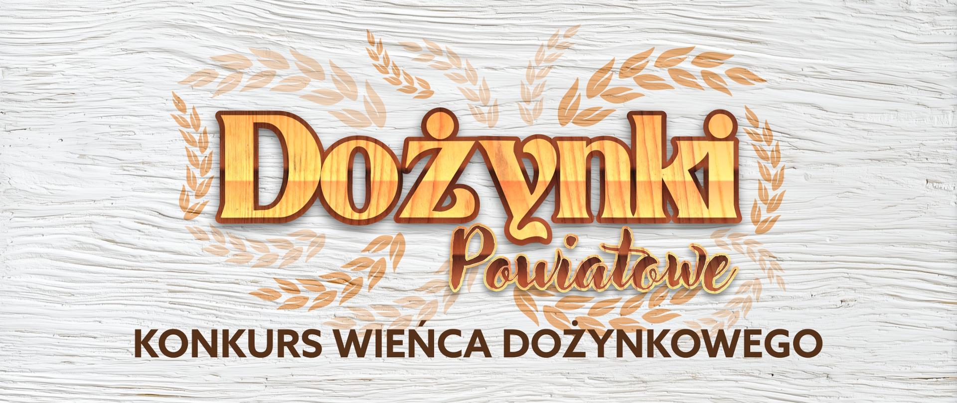Grafika przedstawia pomalowaną białą deskę, na której znajduje się otoczony wizerunkami kłosów zbóż napis "Dożynki Powiatowe", a pod nim nazwa konkursu "Konkurs wieńca dożynkowego" w kolorze brązowym.