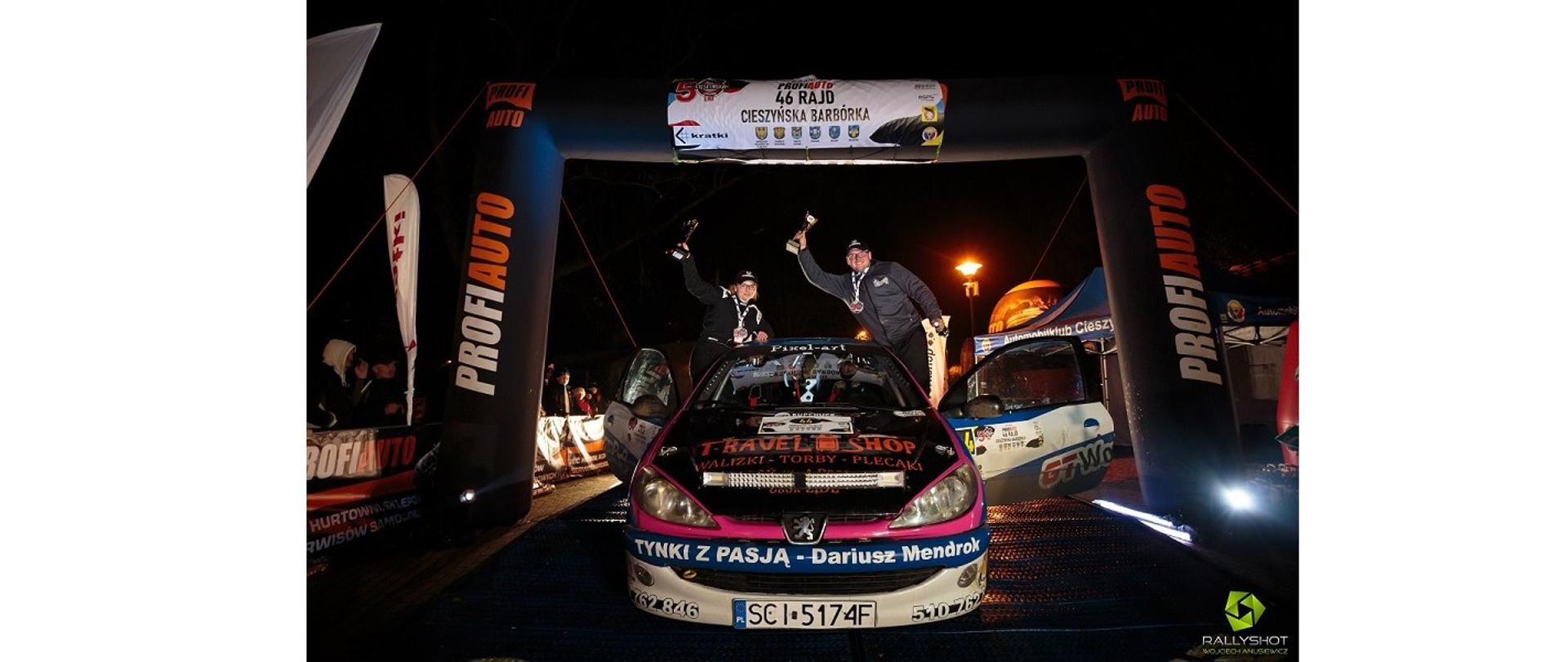 Marcin i Alicja Biernat po zwycięskim dla nich Rajdzie Cieszyńskiej Barbórki 2022. Na mecie rajdu przy swoim samochodzie, wznosząc radośnie puchary. Fot. Rallyshot Wojciech Anusiewicz