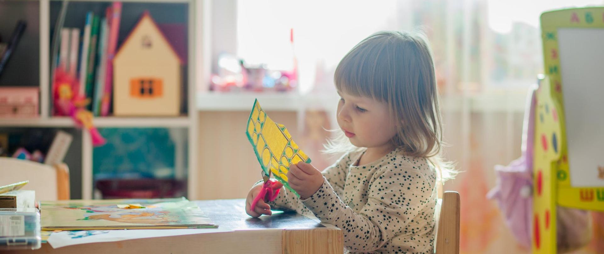 grafika przedstawia bawiące się dziecko