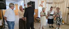 Mężczyzna wręcza grupie osób róże.