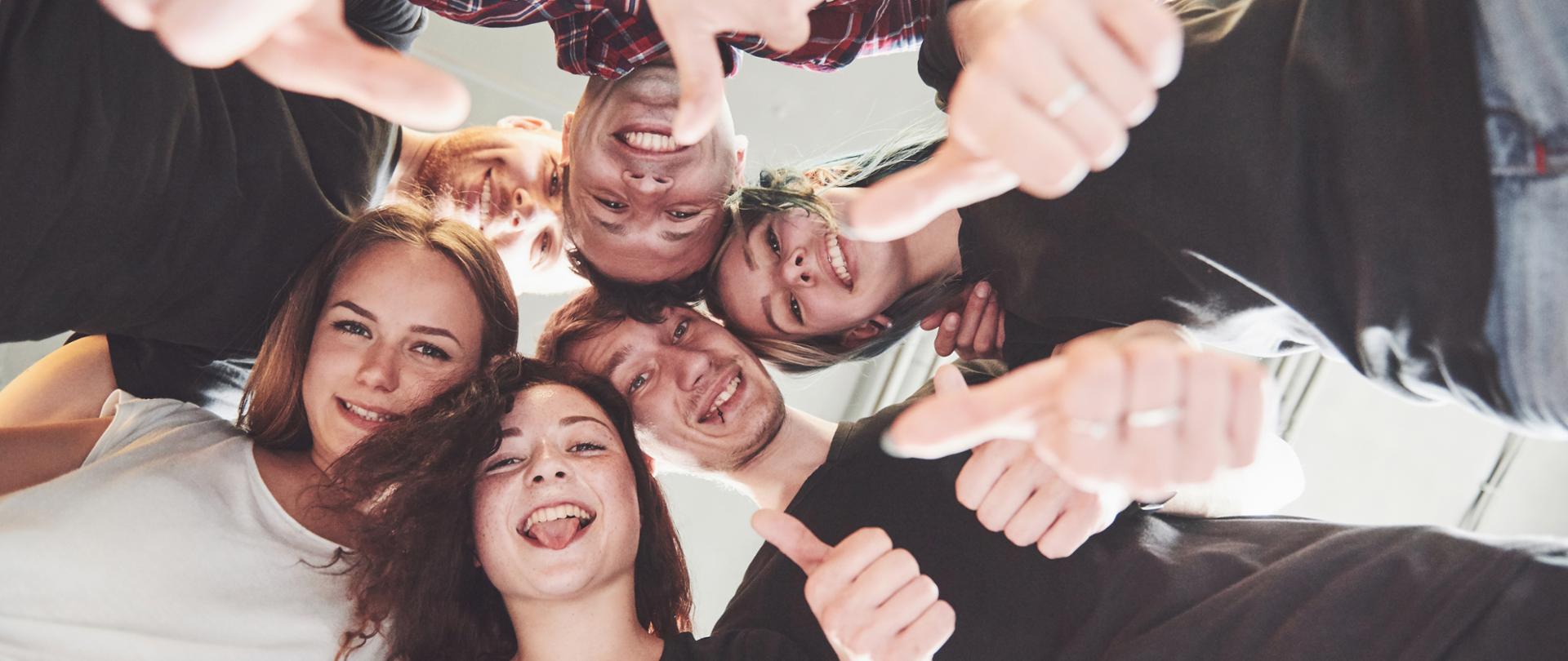 Happy group of friends with their hands together in the middle.