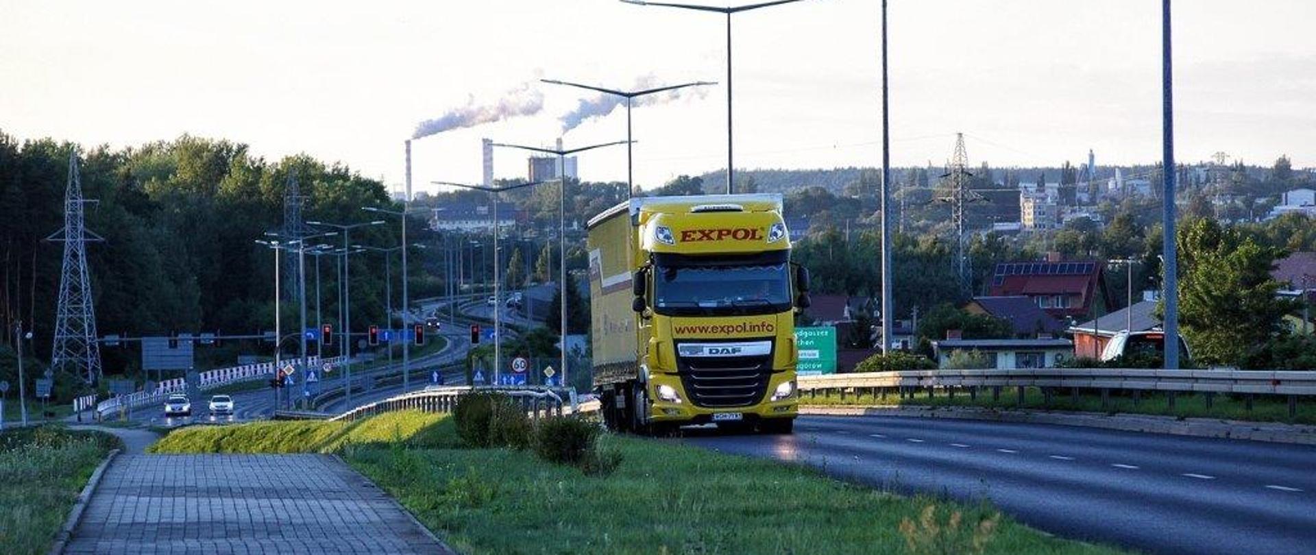 grafika przedstawia miasto i samochód ciężarowy podczas jazdy