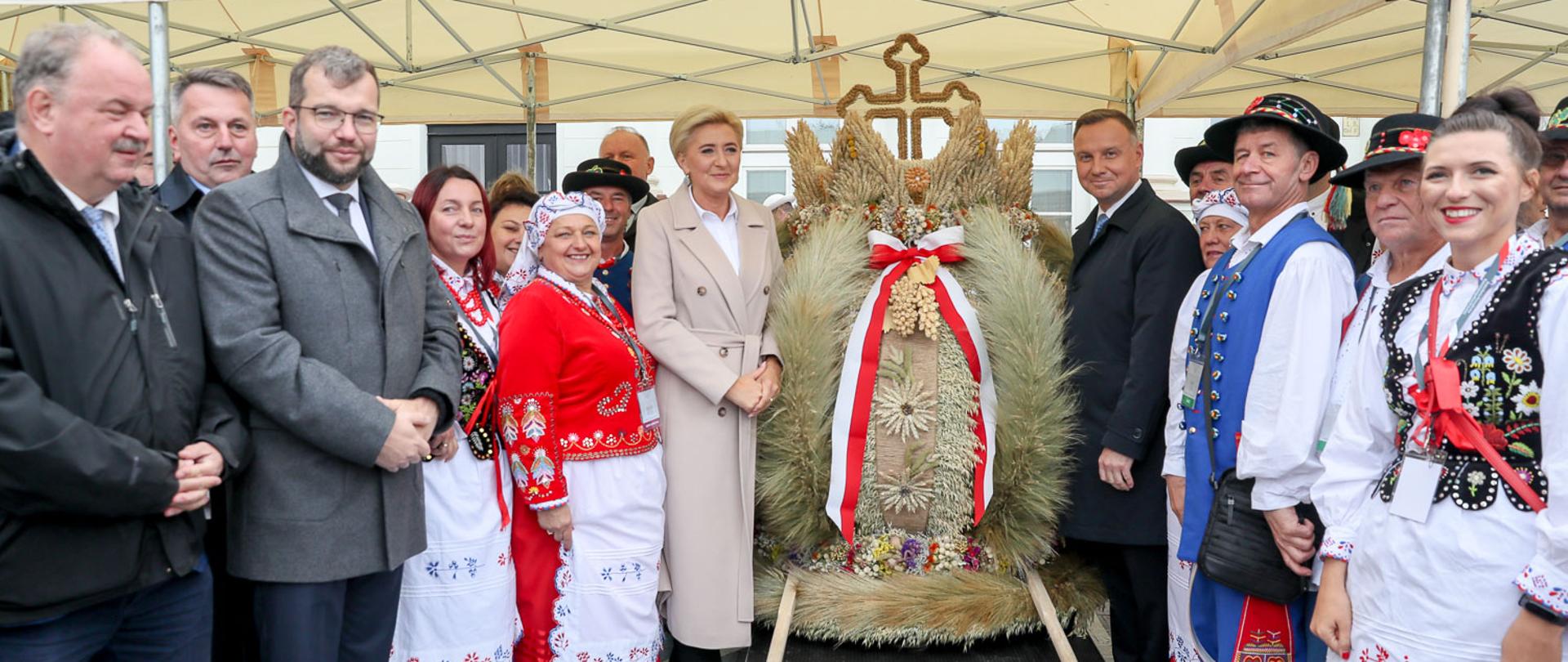 Ludzie między, którymi znajduje się wieniec dożynkowy