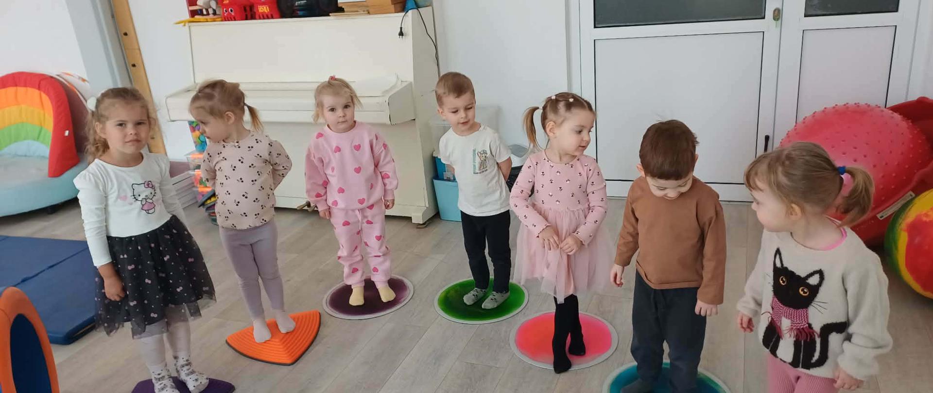 Dzieci podczas zabaw w sali - dzieci stoją na matach